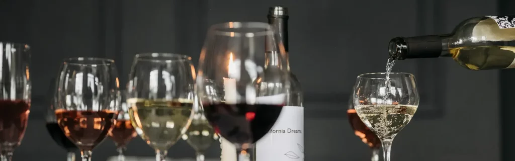 Weisswein wird aus einer Flasche zur Verk&ouml;stigung in ein exclusives Glas eingeschenkt